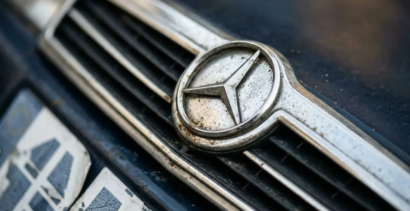 Close-up van een klassieke Mercedes dieselauto uit de jaren '80 met belastingpapieren op motorkap