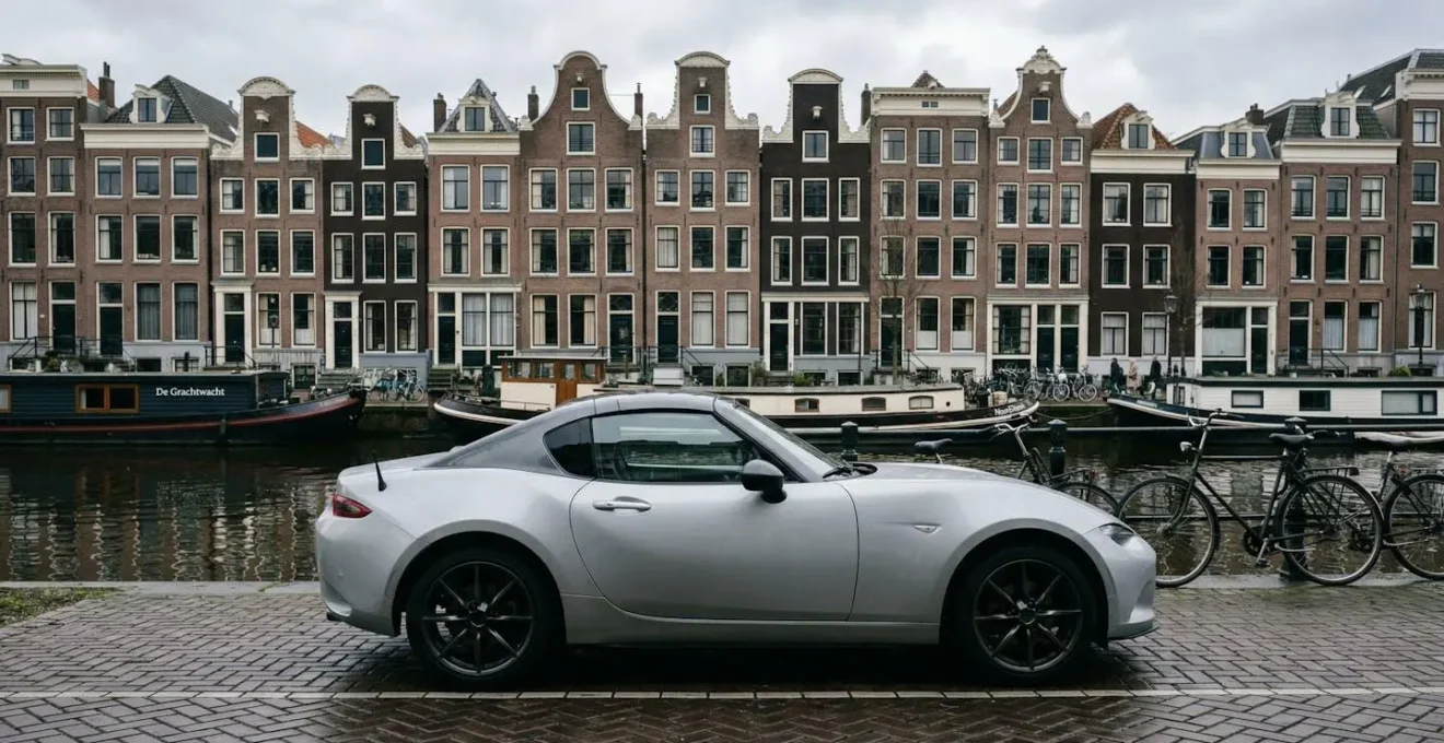Zijaanzicht van een gesloten hardtop cabriolet in een Nederlandse stedelijke omgeving.